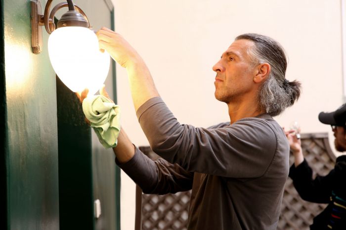 Ein MItarbeiter unserer Hausmeisterei Problemlos beim Wechseln der Birne und Reinigen der Lampe im Flur