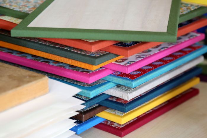 Buchrücken in verschiedenen Farben übereinander gestapelt aus unserer Papierwerkstatt