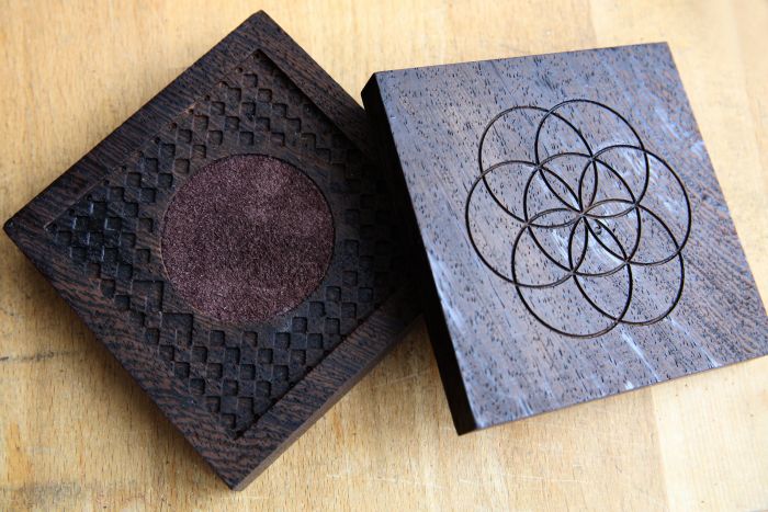 Kunstobjekte aus Holz in quadratischer Form, übereinander liegend mit eingraviertem Blumenmotiv