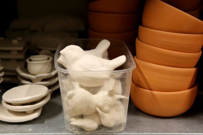 Vögelchen und andere Tiere aus Keramik in einer Plastikschüssel, daneben Schalen aus Keramik